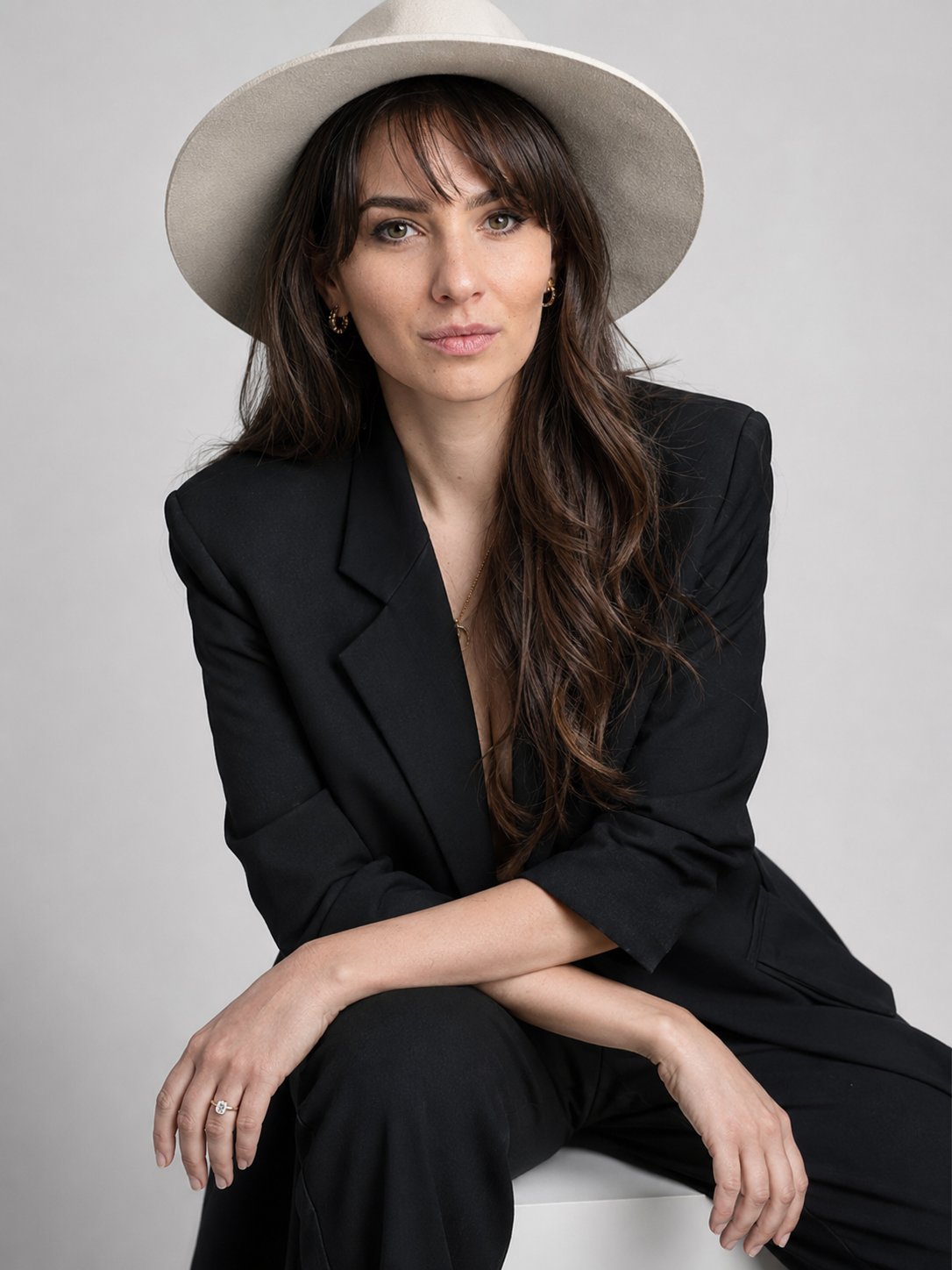 Katerina, founder of KatLok, in a cream suit and wide-brim hat